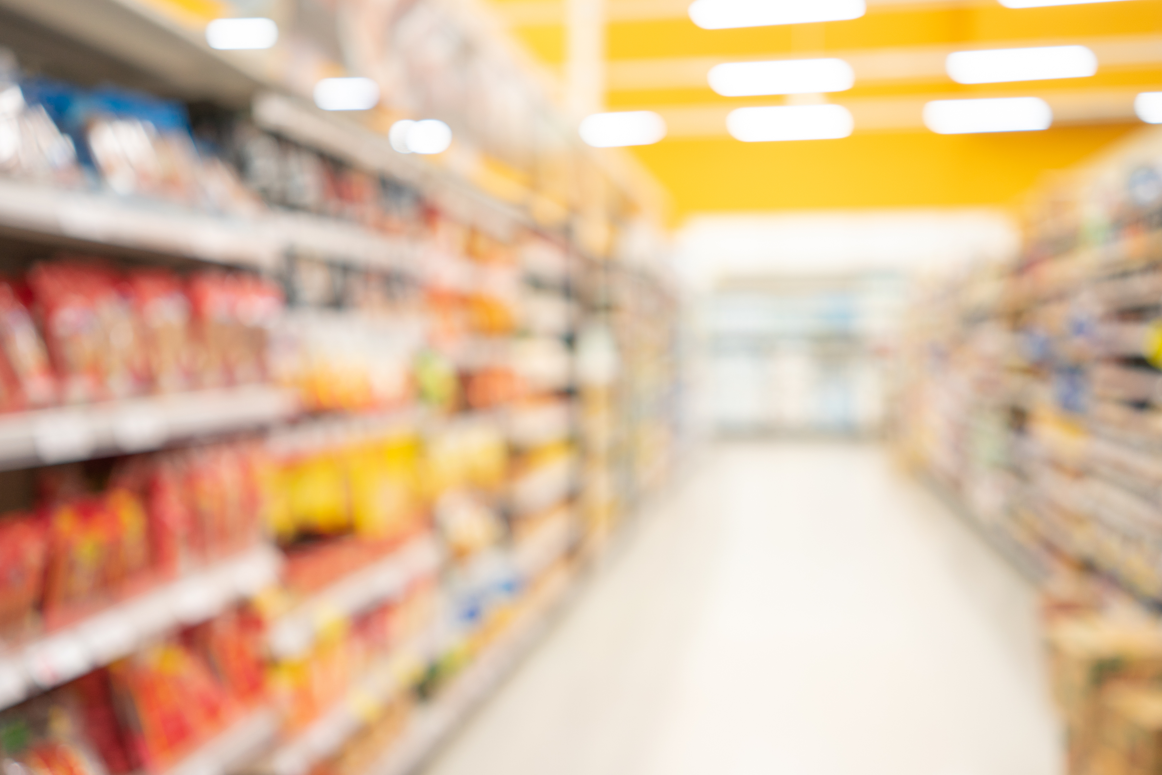 Abstract blurred supermarket view of empty supermarket aisle, defocused  blurry background with bokeh light in store. Business concept. -
